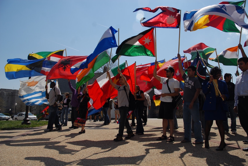 Students carrying flags from various countries